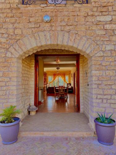 an entrance to a building with a stone wall at QUIET OASIS Luxury Stone Villa with Panoramic Views near Essaouira in Essaouira
