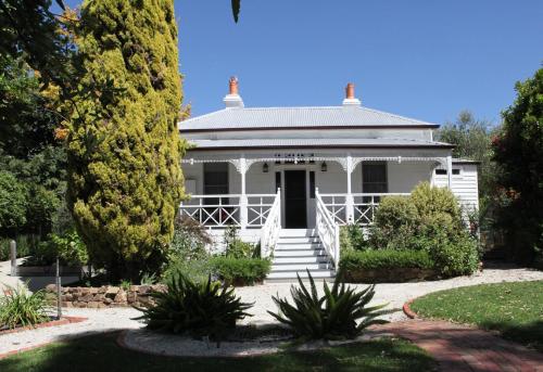a white house with a porch and stairs in a garden at Fairbank House in Maldon