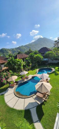 an aerial view of a resort with a pool and umbrellas at Dalia Budget Hotel in Senggigi