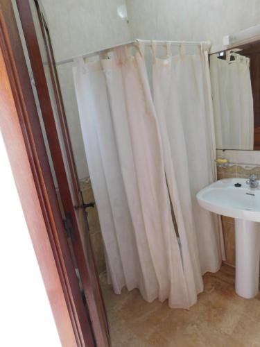 a bathroom with a shower curtain and a sink at Appartement moderne à 5 min de la plage in Cabo Negro