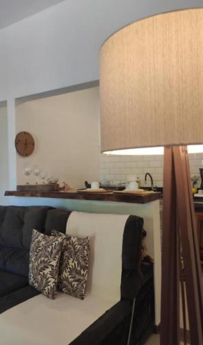 a living room with a couch and a lamp at Suítes Mathias flat 104 in Conservatória