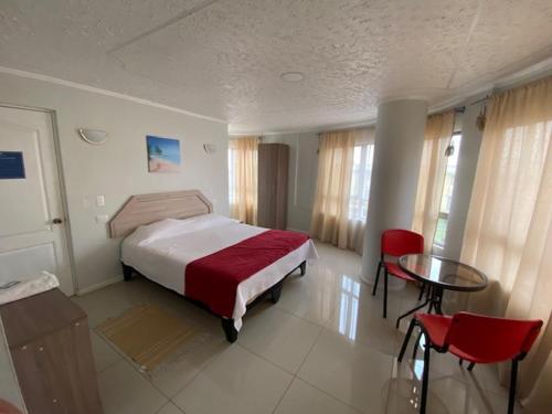 um quarto com uma cama, uma mesa e cadeiras em Hostal Quinta Normal em Antofagasta