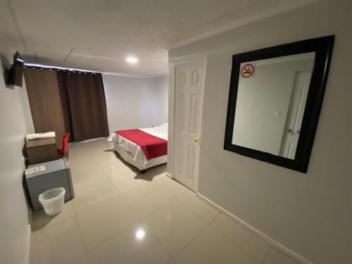 um quarto de hotel com uma cama e um espelho em Hostal Quinta Normal em Antofagasta