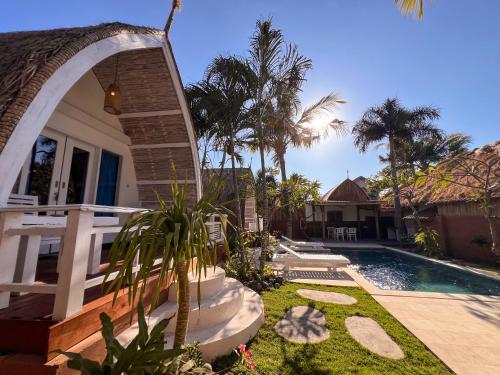 a house with a swimming pool next to a house at Coconut Dream Villas in Gili Trawangan