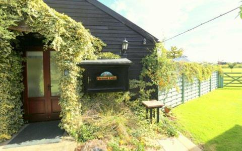 a house with a door and a bench in front of it at Pheasant Suites in Colchester