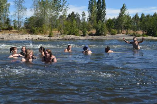 a group of people swimming in the water at Coyunche Cabañas y Camping Laja & San Rosendo in Laja
