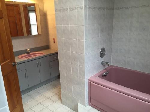 a bathroom with a pink tub and a sink at Private house with 4 bedrooms and 2 bathrooms and direct NYC Manhattan train only 10 minute walk away in Edison