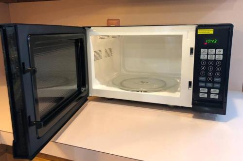 a microwave oven with its door open on a counter at Private house with 4 bedrooms and 2 bathrooms and direct NYC Manhattan train only 10 minute walk away in Edison