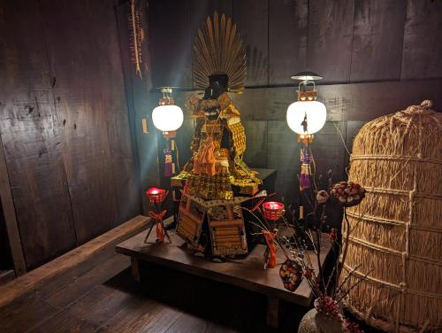 a room with a table with a statue and lights at みのり家 - Samurai-era house - 昔の暮らし体験 in Takayama