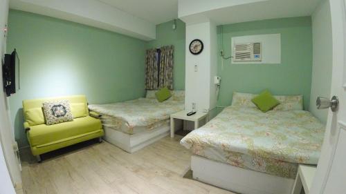 彰化市的住宿－心旅地圖青年旅館，一间卧室配有两张床和一张黄色椅子
