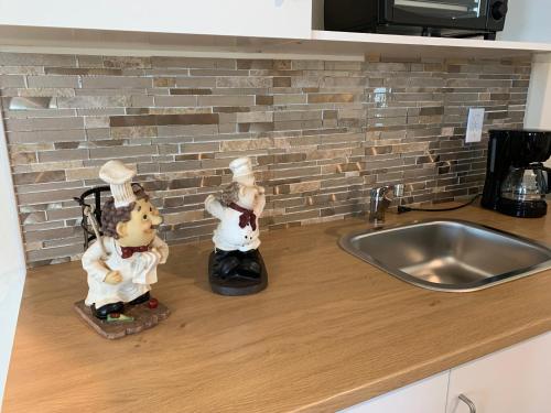 2 figurines assises sur un comptoir de cuisine à côté d'un évier dans l'établissement Home SWEET HOME, à Davenport