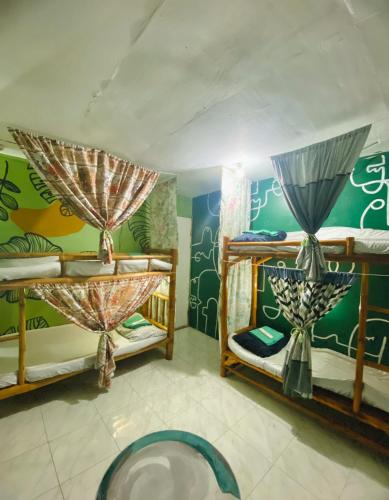 a room with two bunk beds and a mural at Byahero's Eskapo Hostel in Moalboal