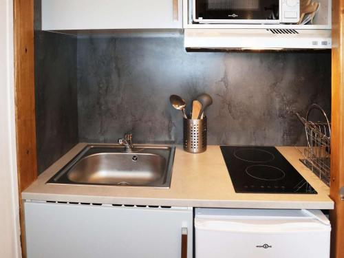 Il comprend une cuisine équipée d'un évier et d'une cuisinière. dans l'établissement Studio cosy pour 2 en cœur de station aux Orres - FR-1-322-611, aux Orres