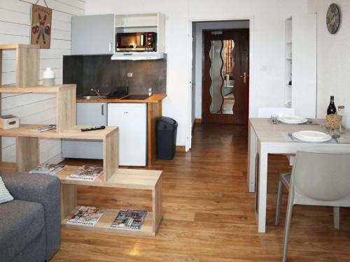 un salon avec un canapé et une table et une cuisine dans l'établissement Studio cosy pour 2 en plein centre, Les Orres 1650 - FR-1-322-612, aux Orres
