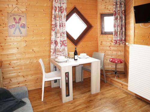 une salle à manger avec une table blanche et une fenêtre dans l'établissement Studio pour 2 au cœur des Orres 1650 avec balcon et box à skis - FR-1-322-615, aux Orres