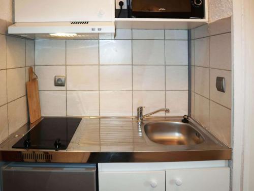 une petite cuisine avec un évier et un micro-ondes dans l'établissement Studio pour 2 au cœur des Orres 1650 avec balcon et box à skis - FR-1-322-615, aux Orres