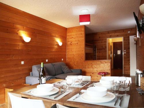 une salle à manger avec une table avec des assiettes et des verres à vin dans l'établissement Studio 4 personnes au cœur des Orres 1650 - FR-1-322-617, aux Orres