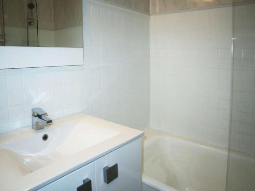 La salle de bains blanche est pourvue d'un lavabo et d'une baignoire. dans l'établissement Studio 4 personnes au cœur des Orres 1650 - FR-1-322-617, aux Orres