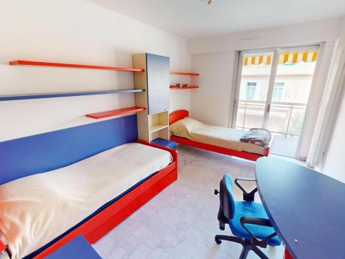 Cette chambre comprend deux lits, un bureau et une table. dans l'établissement Superbe 3P avec Terrasse, Plein Centre de Menton, Proche Mer et Commerces - FR-1-196-358, à Menton