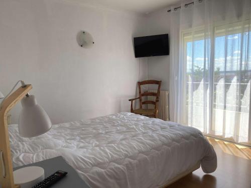 une chambre avec un lit, un bureau et une télévision dans l'établissement Charmant T3 avec Clim et WIFI à Balaruc-les-Bains - FR-1-553-262, à Balaruc-les-Bains