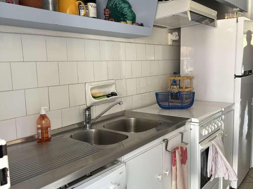 une cuisine avec un évier et un plan de travail dans l'établissement Maison familiale 8 couchages avec terrasse, jardinet, à 500m de la plage - Saint Pierre la Mer - FR-1-229D-133, à Fleury