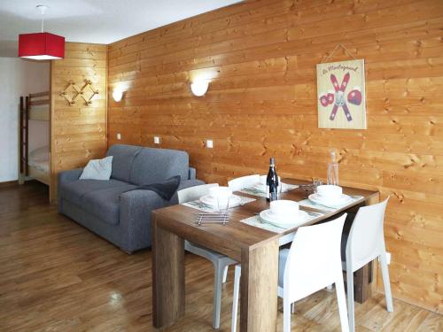 une salle à manger avec une table et un canapé dans l'établissement Studio cosy pour 4 personnes face aux pistes, balcon sud - FR-1-322-616, aux Orres