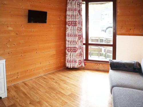 un salon avec un canapé et une fenêtre dans l'établissement Studio cosy pour 3 au cœur des Orres 1650, sur pistes, balcon Est, box ski - FR-1-322-620, aux Orres