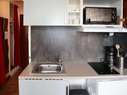 une cuisine avec un évier et un micro-ondes dans l'établissement Studio cosy pour 2 en cœur de station aux Orres 1650 - FR-1-322-627, aux Orres
