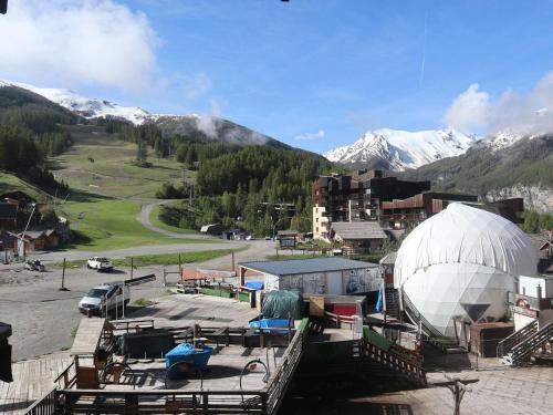 un grand bâtiment blanc en forme de dôme avec des montagnes en arrière-plan dans l'établissement Studio cosy pour 2 en cœur de station aux Orres 1650 - FR-1-322-627, aux Orres
