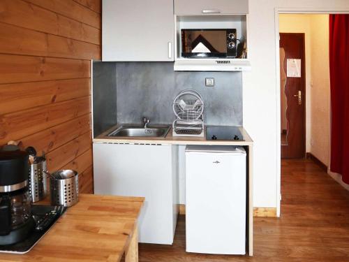 une petite cuisine avec un évier et un micro-ondes dans l'établissement Coquet studio 2 pers au cœur des Orres 1650 - FR-1-322-628, aux Orres