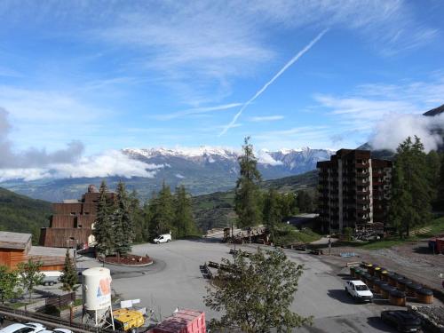- une vue sur un parking avec des montagnes en arrière-plan dans l'établissement Coquet studio 2 pers au cœur des Orres 1650 - FR-1-322-628, aux Orres