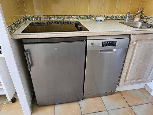 une cuisine avec un évier et un lave-vaisselle dans l'établissement T2 climatisé à 100m de la mer avec piscine et parking - FR-1-768-88, à La Garonnette-Plage