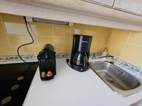- une cafetière sur un comptoir à côté d'un évier dans l'établissement T2 climatisé à 100m de la mer avec piscine et parking - FR-1-768-88, à La Garonnette-Plage
