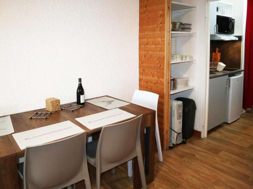 - une table à manger avec des chaises et une bouteille de vin dans l'établissement Studio cosy 4 pers, Les Orres 1650, skis aux pieds - FR-1-322-609, aux Orres