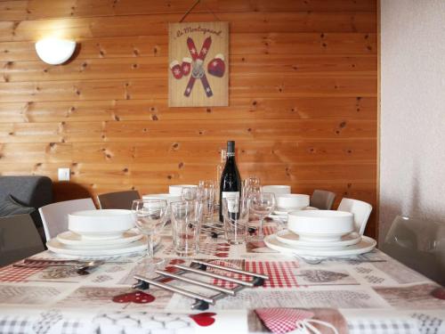 - une table avec des assiettes, des verres et une bouteille de vin dans l'établissement Appartement cosy pour 8 au cœur des Orres 1650 - FR-1-322-624, aux Orres
