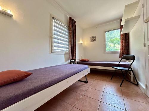 une chambre avec un lit, une fenêtre et une chaise dans l'établissement Les Issambres 3 pièces, 4 pers, piscine, clim, parking - FR-1-226-548, à Roquebrune-sur Argens