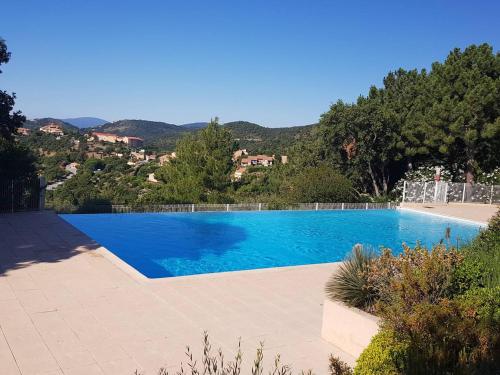une grande piscine bleue avec des montagnes en arrière-plan dans l'établissement Les Issambres 3 pièces, 4 pers, piscine, clim, parking - FR-1-226-548, à Roquebrune-sur Argens