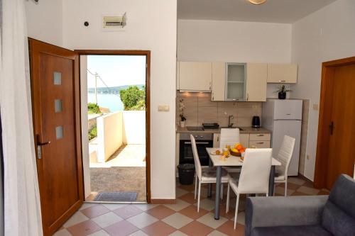 a kitchen and a dining room with a table and chairs at Ibeach By Rok Apartment in Novigrad Dalmatia