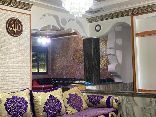 a purple couch in a room with a chandelier at KETAMA feeling in Tlata Ketama