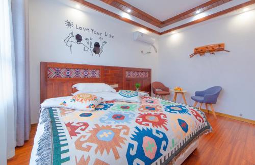 a bedroom with a bed with a colorful comforter at Easy House Gaoyun Branch in Zhangjiajie