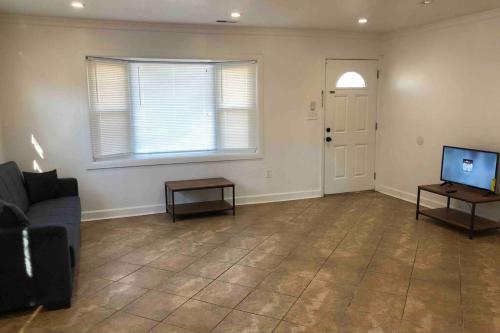 an empty living room with a couch and a television at Private 2-bedroom house, free parking, 15-min walk to direct NYC Manhattan train, MetLife Stadium FIFA World Cup 30 minutes away in Edgar