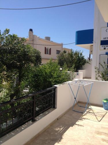 a table on the balcony of a building at Family sea view apartment near the beach in Makry Gialos
