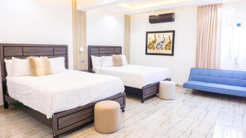 una camera con due letti e un divano blu di Brunei Hotel Boutique a Boca Chica