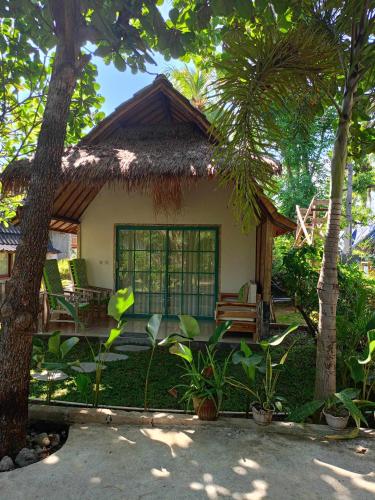 a small house with a thatched roof at Bintang Tiga Bungalows Gili Air in Gili Air