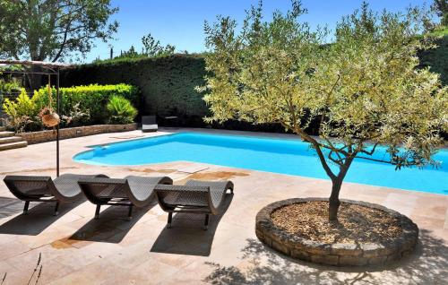 Una piscina con una mesa y un árbol al lado. en La Villa Du Soleil, en Lacoste