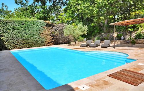 - une piscine dans une cour avec des chaises et un parasol dans l'établissement La Villa Du Soleil, à Lacoste