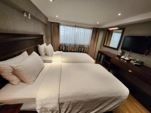 a hotel room with two beds and a flat screen tv at Classic Street Hotel in Hanoi