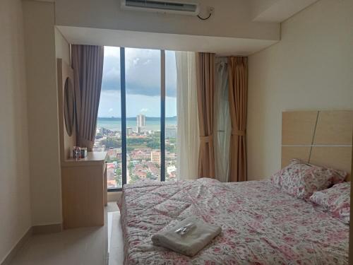 - une chambre avec un lit et une grande fenêtre dans l'établissement Apartement Studio Pollux Habibi Batam A13712, à Batam Center