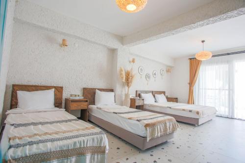 a bedroom with two beds in a room at Glenn Hotel & Beach in Ayvacık