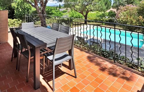 d'une table et de chaises en bois sur un balcon avec piscine. dans l'établissement La Villa Des Pins, à Rochefort-du-Gard